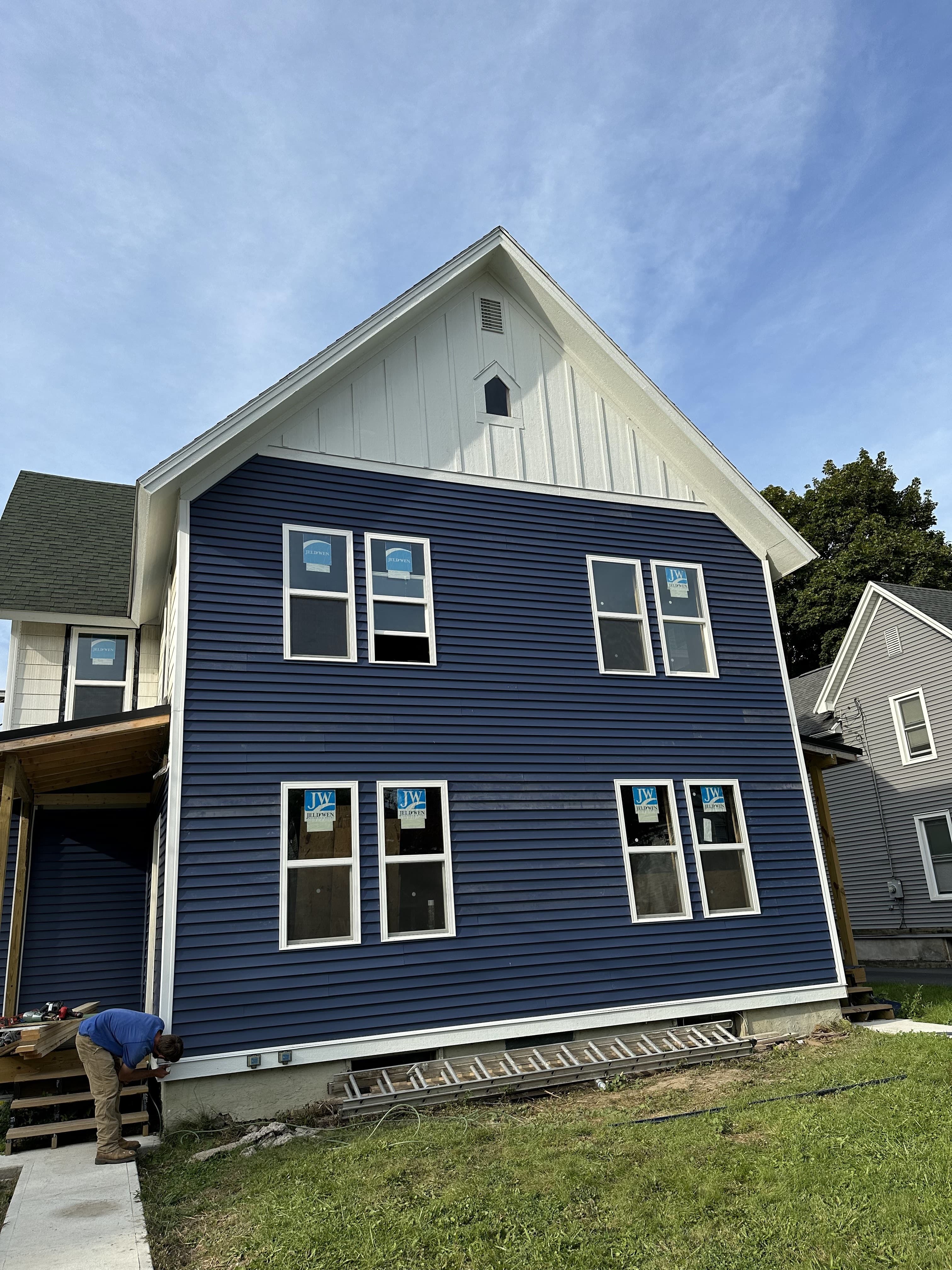 Two-story custom home with navy blue horizontal siding and white trim