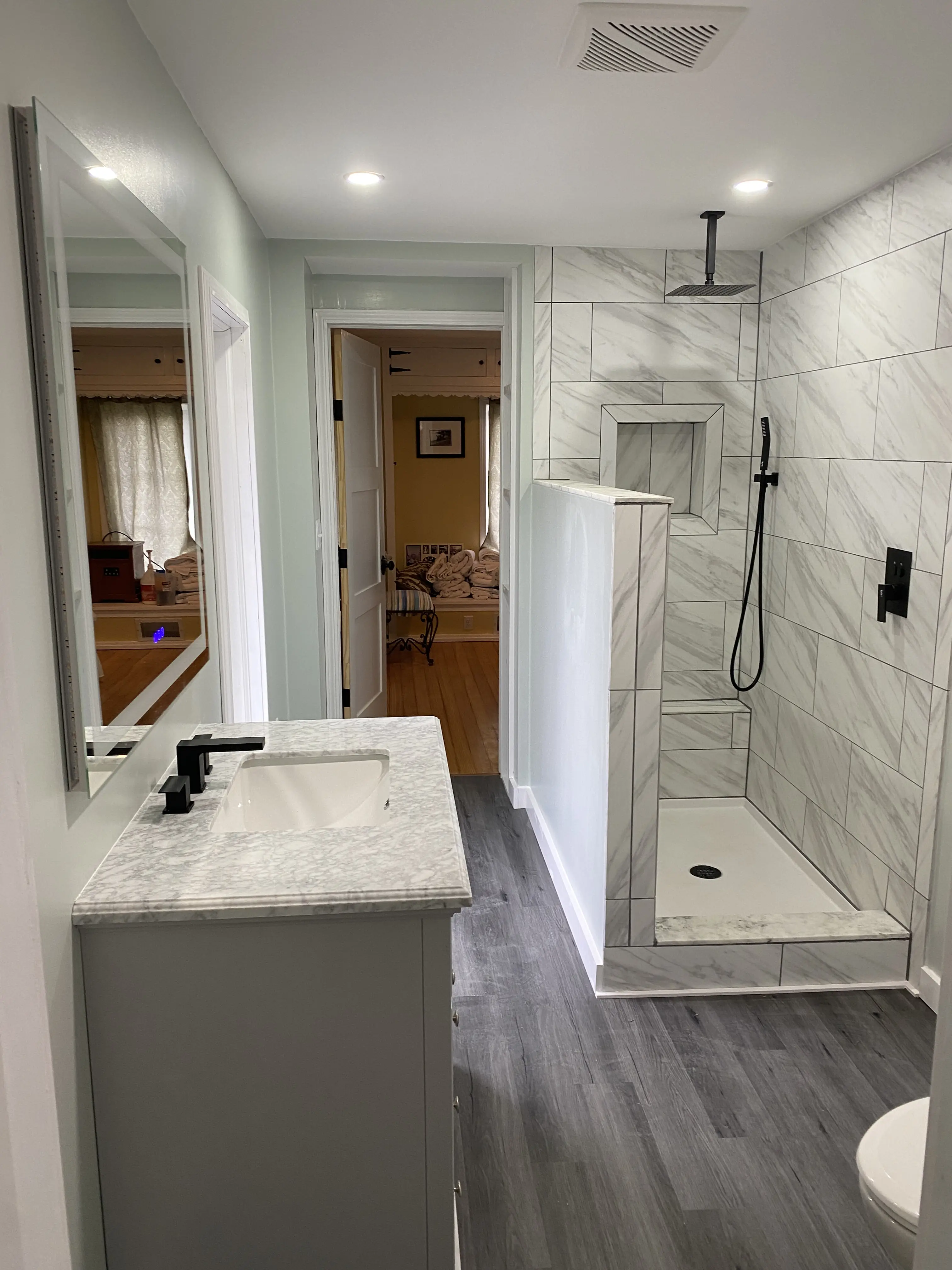 Modern bathroom with marble tile walk-in shower and gray vanity