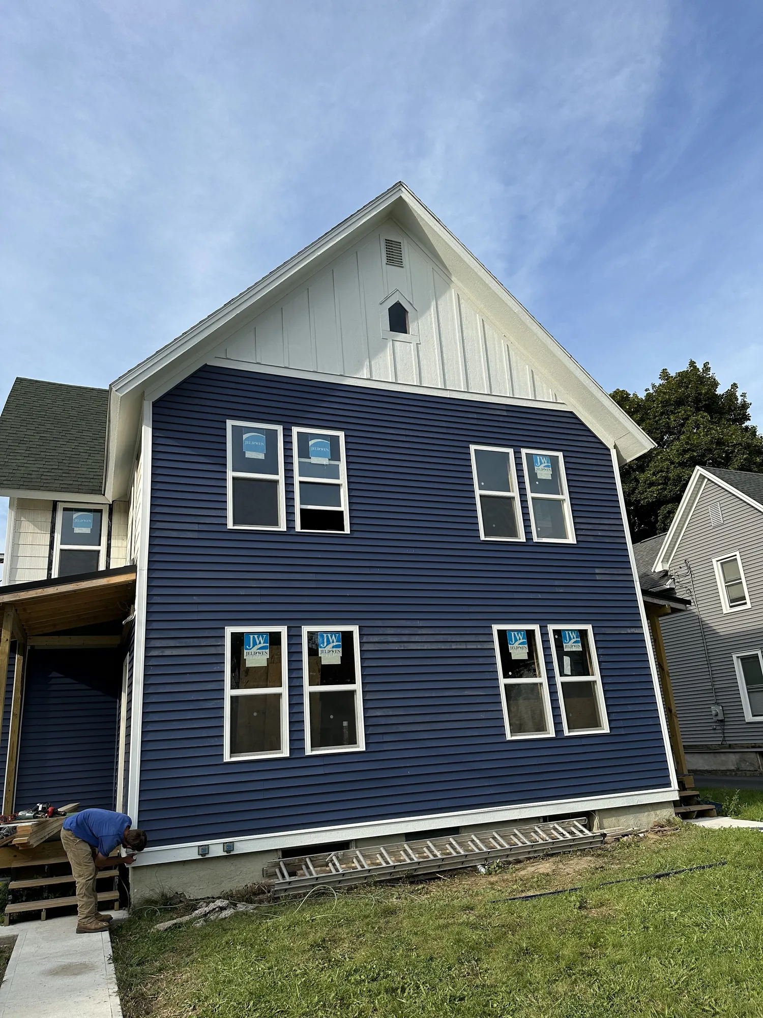 Two-story custom home with navy blue horizontal siding and white trim