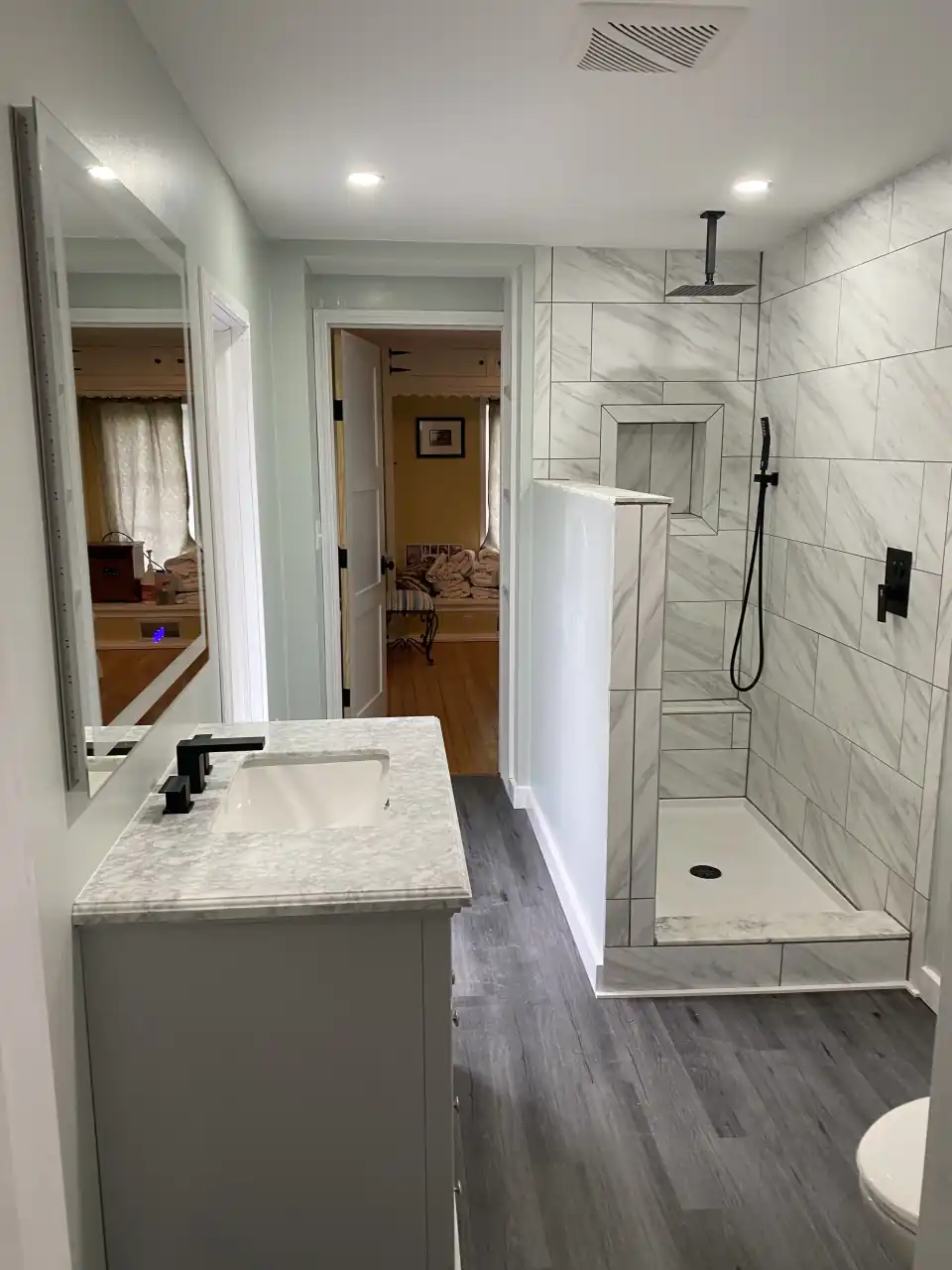 Modern bathroom with marble tile walk-in shower and gray vanity